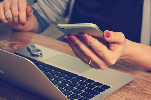 Lady using laptop and mobile phone to browse social media